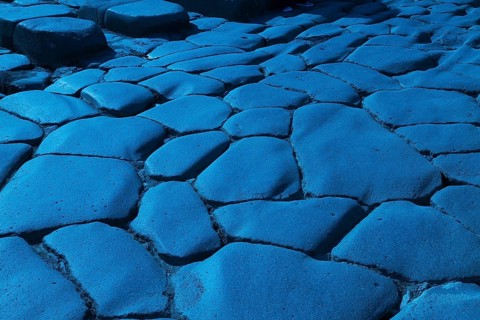 Close-up of large grey smooth and worn lava stones in a street at the ancient ruins of Pompeii,