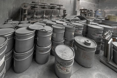 Metal barrels covered with zinc dust in the filling room for zinc powder of a metal powder mill,