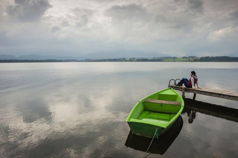 Woman 50-60, wooden jetty, green rowing boat, Hopfensee, Hopfen am See, near Füssen, Ostallgäu,