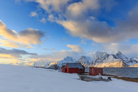 Red boathouses, coast, snowy mountains, fjord, morning light, clouds, snow, Lyngen Alps, Norway,