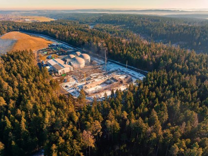 Wide view of a wintry forest area with a construction site and industrial plant, new fire station,
