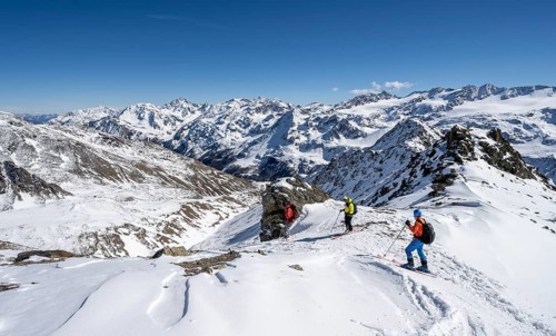 Ski tourers descending from the summit of the Madritschspitze, mountain panorama with snow-covered