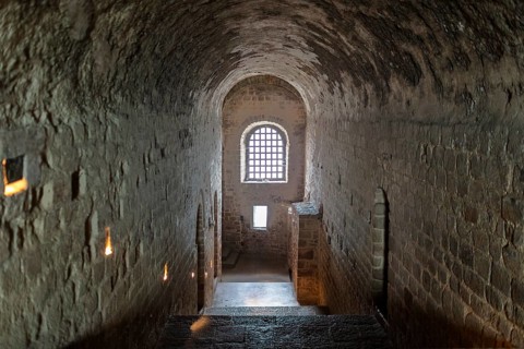 Dark stone corridor with lattice window in medieval style, Le Mont-Saint-Michel