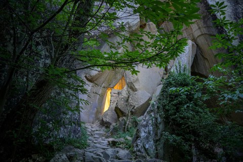 Incidental sun illuminates the passage (Chambre du Roi) through the high rocks, hike through the