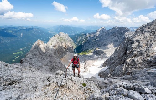 Mountaineer with helmet in a secured via ferrata, Zugspitze via ferrata, ascent to the Zugspitze,