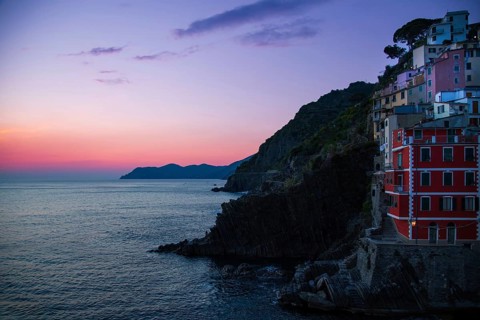 Italy, Riomaggiore colorful buildings overlooking scenic shoreline. Cinque Terre landscapes in