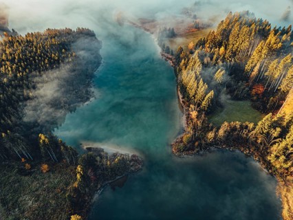 Autumn sunrise in the foothills of the Alps with fog at Illasbergsee and Forggensee near Halblech