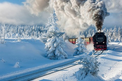 Snow-covered winter landscape with snow-covered spruce forest, the Brocken railway travelling to