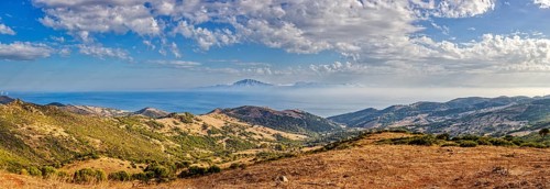 Panorama of a wide hilly landscape with a view of the sea, near Tarifa, view to Morocco
