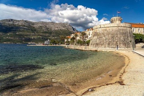 Luka Korculanska beach and the large prince's tower and the old town centre of Korcula, Croatia,