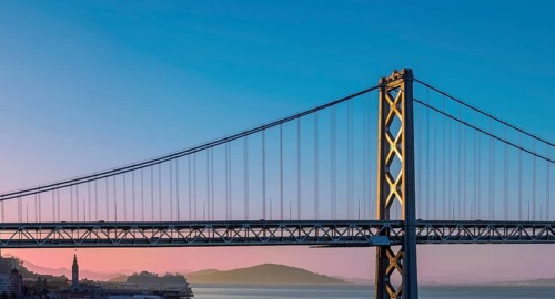 Cruise ship docked near panoramic San Francisco financial skyline near Oakland Bay Bridge.