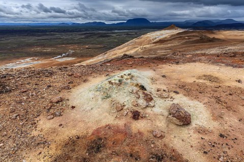 Geothermal field and sulphur springs in front of mountain landscape, clouded, Namafjall, Myvatn,