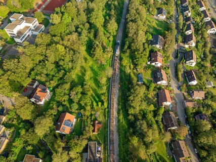 Railway line through green residential areas and landscapes, track construction, rail delivery for
