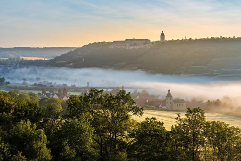 View of Freyburg with Neuenburg Castle, in front the church of Nißmitz, morning fog in the Unstrut