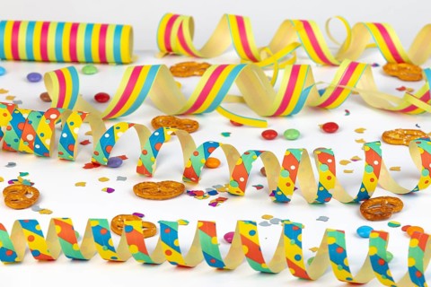 Colourful streamers, confetti and pretzels as party table decorations, carnival