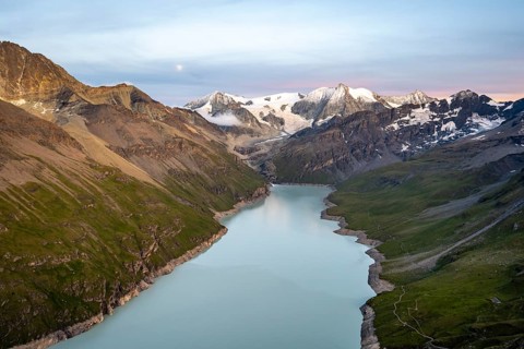 Picturesque mountain landscape at the summit Mont de la Blana at sunset with full moon, view of