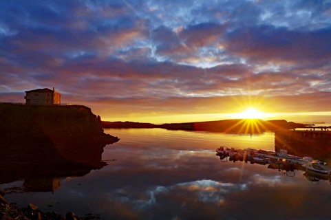 Sunset over the sea with reflecting clouds and a calm coast, Stykkisholmur, Snaefelsnes, Iceland,