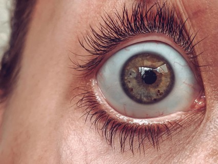 Detailed close-up of a wide-open eye with long eyelashes