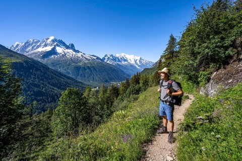 Mountaineer on hiking trail, mountain panorama with glaciated mountain peaks, Aiguille Verte with