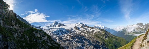 High alpine mountain landscape with sun star, summit of Aiguille de Chardonnet and Glacier du Tour,