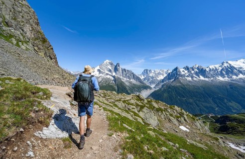 Mountaineer on a hiking trail in front of a mountain landscape, view of the mountain peaks Aiguille