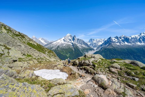 Mountaineer on a hiking trail in front of a mountain landscape, view of the mountain peaks Aiguille