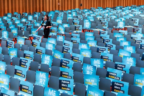 Assembly hall, deserted with many empty chairs and posters with the inscription UNSER KANNZLER.