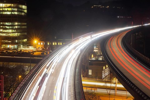 Federal road B14 at night, road bridge with traffic and light lanes. On the left the building of