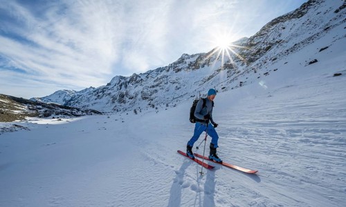 Ski tourers in the rear Martell Valley, snow-covered mountain landscape with sun star, Ortler Alps,