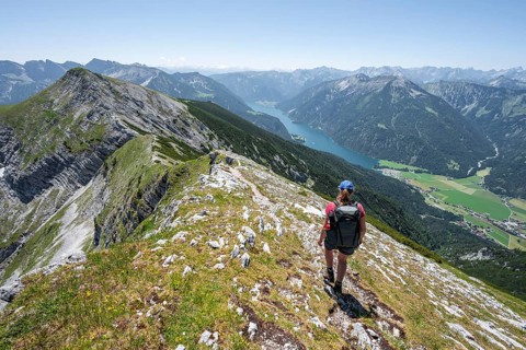 Mountaineer on the summit ridge of the Unnütz, behind Achensee and summit of the Seekarspitze