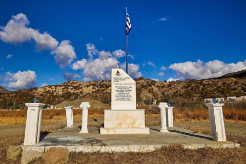 Greek monument with flag under clear blue sky and mountainous background landscape, Christopher