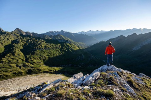 Mountaineer in front of mountain landscape at sunrise, view of mountain peaks of the Venediger