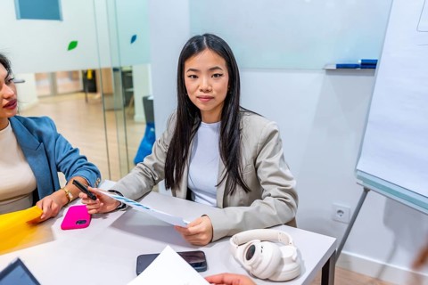 Young asian businesswoman leading a meeting with colleagues in a modern coworking office,