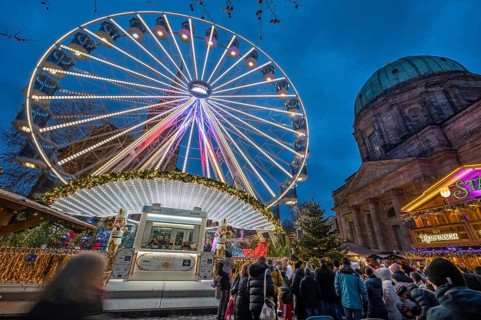 Ferris wheel at the winter village, Christmas market at dusk, St Elisabeth's Church on the right,