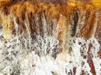 Detail of a waterfall in the Rio Tinto (Red river) with its orange-red hue due to oxidised iron
