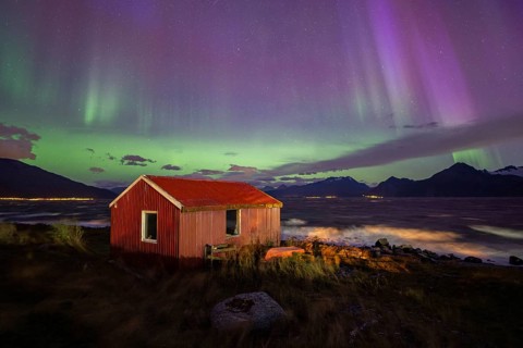 Northern Lights over a hut at the Lyngenfjord, Lyngen Alps, Lyngen, Troms og Finnmark, Norway,