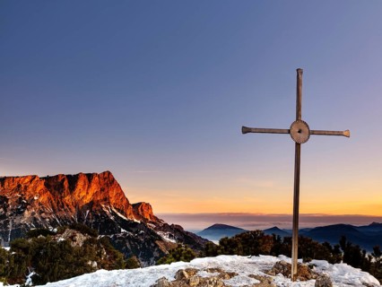 Sunrise at the summit cross of the Rauhen Kopf, behind the Untersberg, Berchtesgaden Alps,