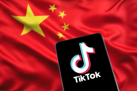 TikTok logo from China with Chinese flag social media on a mobile phone in Stuttgart, Germany,
