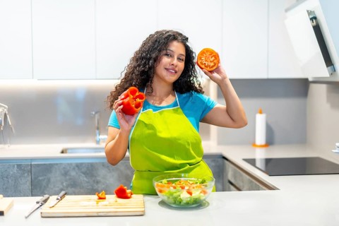 Cool latin young food vlogger showing ingredients while recording a cooking tutorial at home