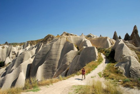Hiker between tuff rocks, Rose Valley, Rose Valley, Cappadocia, Turkey, Asia