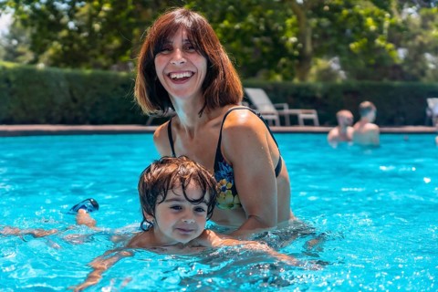 Mother and son in the pool on summer vacation, learning to swim with his mother