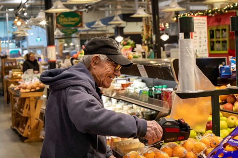 London, Ontario, Canada - A shopkeeper puts prices on his produce at Covent Garden Market.