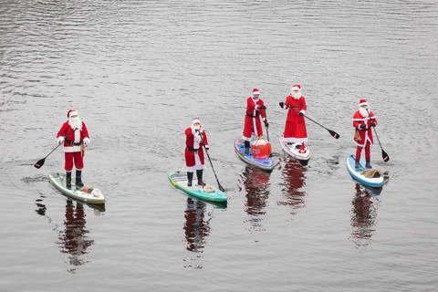 Water sports enthusiasts dressed as Santas ride SUPs on the Spree in Berlin on 14 December 2024
