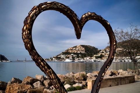 View through a heart of stones to the harbour of Port d'Andratx with marina, Majorca, Balearic