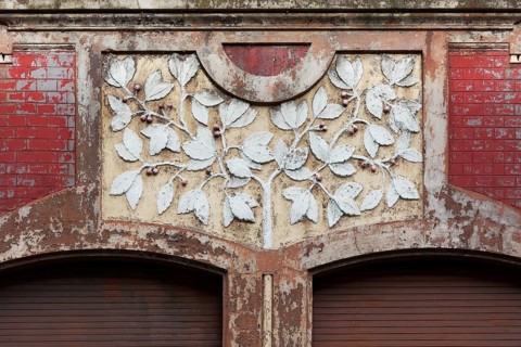 Facade decoration on a Wilhelminian style house for renovation, branches with cherries, detail,