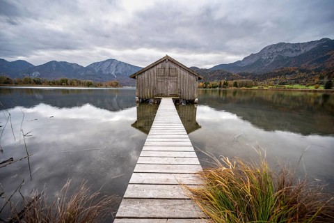 Boathouse in the lake, Lake Kochel in autumn with reflection, Upper Bavaria, Bavaria, Germany,