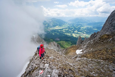 Mountaineer on the rocky ridge, ascent to the Ackerlspitze, clouds moving around the mountains,