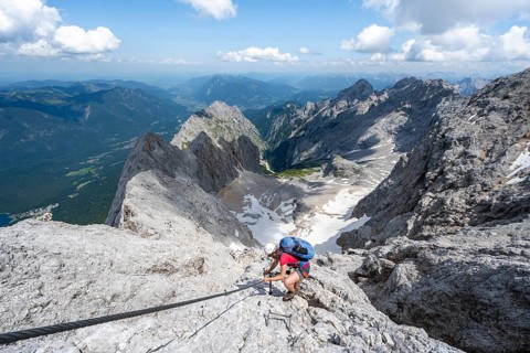 Mountaineer with helmet in a secured via ferrata, Zugspitze via ferrata, ascent to the Zugspitze,