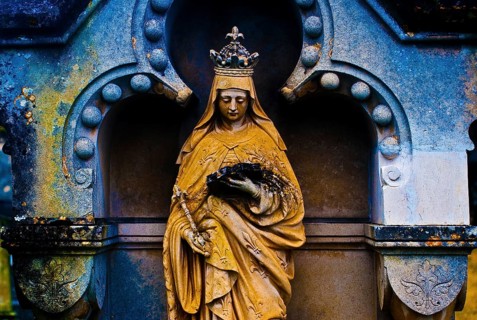 Sculpture of the Virgin Mary reading a book, tombstone in a cemetery, France, color manipulation,