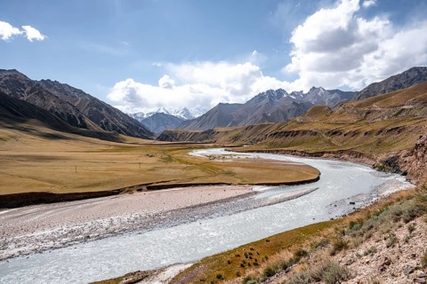 Mountain river in a valley, picturesque mountain landscape with white mountain peaks, Tian Shan